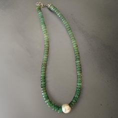 Add a touch of elegance to your collection with this stunning Smooth Green Quartz Necklace. Featuring smooth green quartz rondelle gemstones and an exquisite single round pearl as the focal point, this 18-inch necklace is perfect for those who love minimalist yet eye-catching designs. The silver lobster clasp ensures a secure and comfortable fit, making it an ideal choice for everyday wear or special occasions. The soft green hues of the quartz combined with the classic pearl create a harmonious Gift Rondelle Emerald Necklace With Natural Stones, Elegant Rondelle Emerald Necklace With Natural Stones, Green Rondelle Jewelry With Natural Stones, Green Rondelle Gemstone Jewelry, Rondelle Pearl Necklace With Gemstone Beads As Gift, Green Rondelle Emerald Necklace For Gift, Green Rondelle Emerald Necklace As Gift, Green Gemstone Rondelle Jewelry, Green Rondelle Emerald Necklace Gift