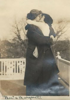 an old black and white photo of two people hugging