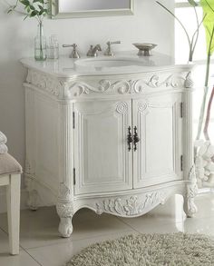 a white bathroom vanity with a mirror above it and a rug on the floor next to it