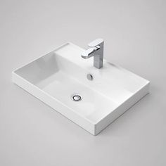 a white sink sitting on top of a counter next to a faucet and soap dispenser