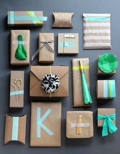 many wrapped presents are laid out on the table with ribbons and paper decorations around them