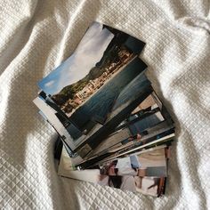 several photographs are stacked on top of each other in the middle of a bed spread