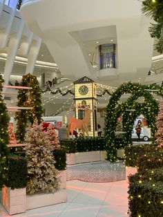 christmas decorations are displayed in the lobby of a shopping mall, decorated with lights and garlands