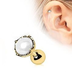 a pair of ear piercings with pearls and gold plated posts, on top of a white background