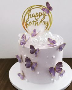 a white cake with purple butterflies on it