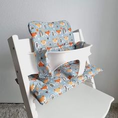 a white rocking chair with blue and orange fabric