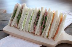 a cut in half sandwich sitting on top of a cutting board next to a napkin