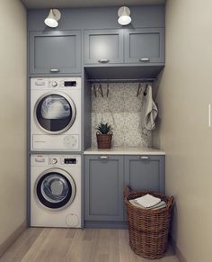 a washer and dryer in a small room with light blue cabinets, white counter tops and wood flooring