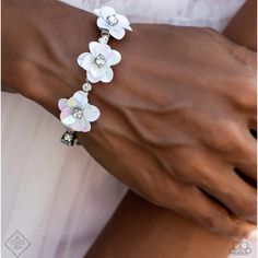 Shiny Silver Beads, White Rhinestones In Sleek Silver Frames, And Varying Sizes Of Iridescent Gems In The Same Silver Frames Are Threaded Along A Wire That Coils Around The Wrist To Create An Infinity Wrap Style Bracelet. At The Center Of The Design, A Trio Of White Iridescent Flowers With White Rhinestone Centers Emerges, Adding A Touch Of Whimsical Color And Three-Dimensional Texture. Due To Its Prismatic Palette, Color May Vary. Sold As One Individual Bracelet. White Wedding Jewelry For Spring, Spring Wedding White Jewelry, Elegant Adjustable Crystal Bracelet For Spring, White Party Bracelets With Rhinestones, White Rhinestone Bracelets For Party, Adjustable Sparkling White Bracelets, White Rhinestone Jewelry For Party, White Pearl Jewelry With Rhinestones, Sparkling White Jewelry For Party