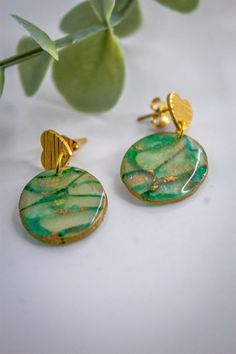 "Green and gold handmade polymer clay dangle earrings. By virtue of the materials, each pair will have slight variations making every pair one of a kind.  Semi-transparent and covered with resin for smooth shine 1\" length 0.5\" width at widest part.  I do my best to make my pictures show the true color but all monitors are different so colors may vary slightly from those shown.  All my earrings are handmade so slight imperfections may occur." Green Heart Drop Earrings For Gifts, Hand Painted Gold Polymer Clay Earrings, Green Heart-shaped Earrings For Gifts, Unique Heart Drop Earrings As Gift, Handmade Green Heart Earrings For Gift, Handmade Green Heart Earrings As Gift, Handmade Polymer Clay Heart Earrings Gift, Gold Round Polymer Clay Earrings, Handmade Heart-shaped Resin Earrings