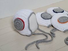 two crocheted objects are laying on the floor next to each other and one is wearing a hat