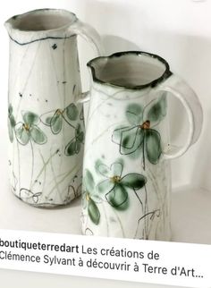 two green and white vases sitting next to each other