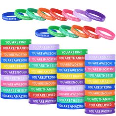 rainbow colored wristbands with you are awesome written on each one in different languages