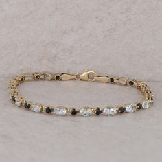 The ladies 14k yellow gold bracelet has seventeen round sapphires and sixteen oval white topaz stones. The bracelet is 3.3mm in width and 7" in length. It weighs 4.60 grams and has a lobster clasp. The sapphires are set in 3 prongs and the topaz stones are set in 4 prongs. Condition: Pre-Owned *All items are thoroughly inspected for quality assurance purposes Fine Jewelry Blue Topaz Round Bracelets, Elegant Gold Bracelets With Blue Topaz, Luxury Yellow Gold Bracelets With Blue Topaz, Luxury Yellow Gold Blue Topaz Bracelets, Elegant Blue Multi-stone Bracelet, Round Sapphire, Yellow Gold Bracelet, Topaz Stone, Fine Jewelry Bracelets