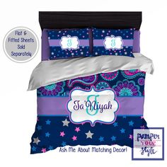 a bed with purple, blue and white comforter set on it's side