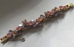 "Delizza and Elster, Juliana design with pink rhinestones and givre lavender satin glass teardrop accents. Beautiful, sparkling diamond like gems on this lovely link bracelet with a gold finish. A larger pink chaton is on a link that links two other ornate gem clusters. A total of five clusters and six large gem connectors. There is a chain guard as well as the very secure clasp. Wear this lovely bracelet on your fanciest outing. Quite a stunning and rare Juliana by Deliza and Elster from their Pink Crystal Bracelet With Rhinestones, Pink Sparkling Stones Bracelet For Wedding, Pink Wedding Bracelets With Sparkling Stones, Pink Crystal Bracelet With Sparkling Stones For Party, Pink Crystal-embellished Jewelry For Party, Pink Crystal Embellished Jewelry For Party, Vintage Pink Bracelets For Wedding, Pink Crystal Bracelet For Formal Occasions, Pink Crystal Bracelets For Formal Occasions