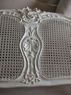 a white bench with intricate carvings on the back