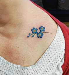 a small blue flower on the back of a woman's neck