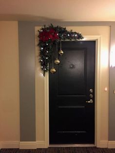 a black door with christmas decorations on it