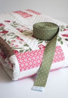 a close up of a piece of cloth with a green ribbon on top of it