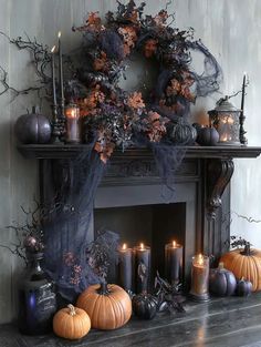 a mantel with candles, pumpkins and other halloween decorations on top of it