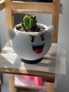 a potted plant with a face painted on it's side sitting on a chair