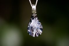 a necklace with a tear shaped pendant hanging from it's side