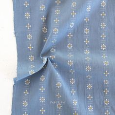 the fabric has daisies on it and is blue with white dots, which have yellow centers