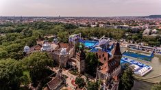 an aerial view of a large building in the middle of trees and buildings around it