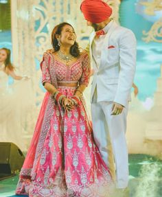 a man in a tuxedo and a woman in a pink lehenga