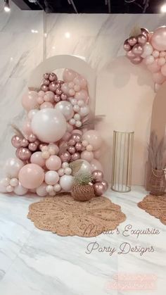 a table with balloons and other decorations on top of it in pink, white and gold colors