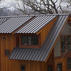 a wooden house with metal roofing and windows