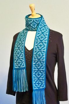 a mannequin wearing a blue scarf and black top with white trimmings