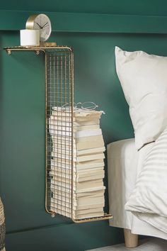 a stack of books sitting on top of a shelf next to a bed