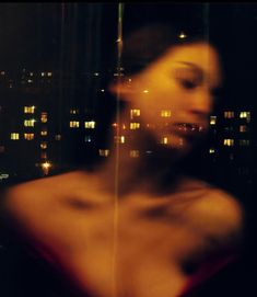 a blurry photo of a woman in front of a cityscape at night