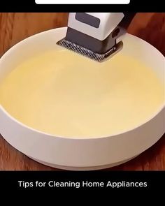 a close up of a person using a machine to clean a bowl