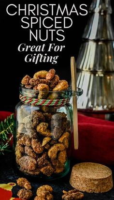 a glass jar filled with nuts next to a christmas tree