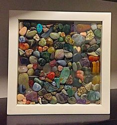 a white frame filled with lots of different colored rocks