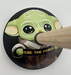 a sticker with an image of a baby yoda holding a pencil in it's mouth