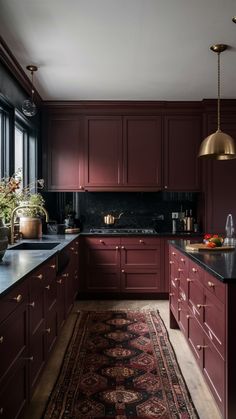 a kitchen with red cabinets and an area rug in front of the counter top that matches the cabinetry