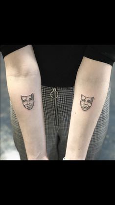 two people with tattoos on their arms and one has a cat face tattooed on the arm