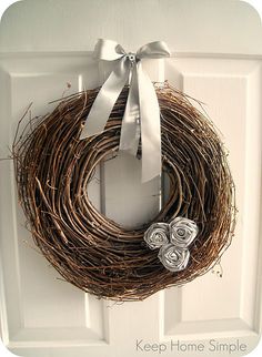 a close up of a door with a wreath on it and two flowers in the middle