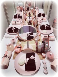 the table is set with pink and black items, such as candles, napkins, plates, and towels