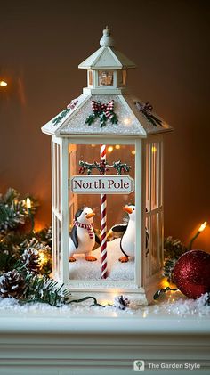 a christmas lantern with two penguins in it