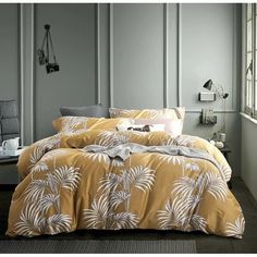 the comforter is yellow and white with palm leaves on it