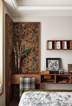 a bedroom with a bed, desk and shelves on the wall next to each other