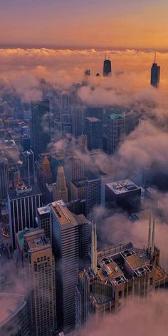 an aerial view of skyscrapers and clouds in the city