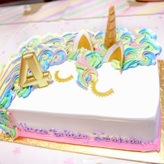 a birthday cake decorated with an unicorn horn and the letter a on it's side