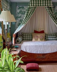 a canopy bed in a bedroom with green and white wallpaper