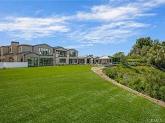 a large house sitting on top of a lush green field